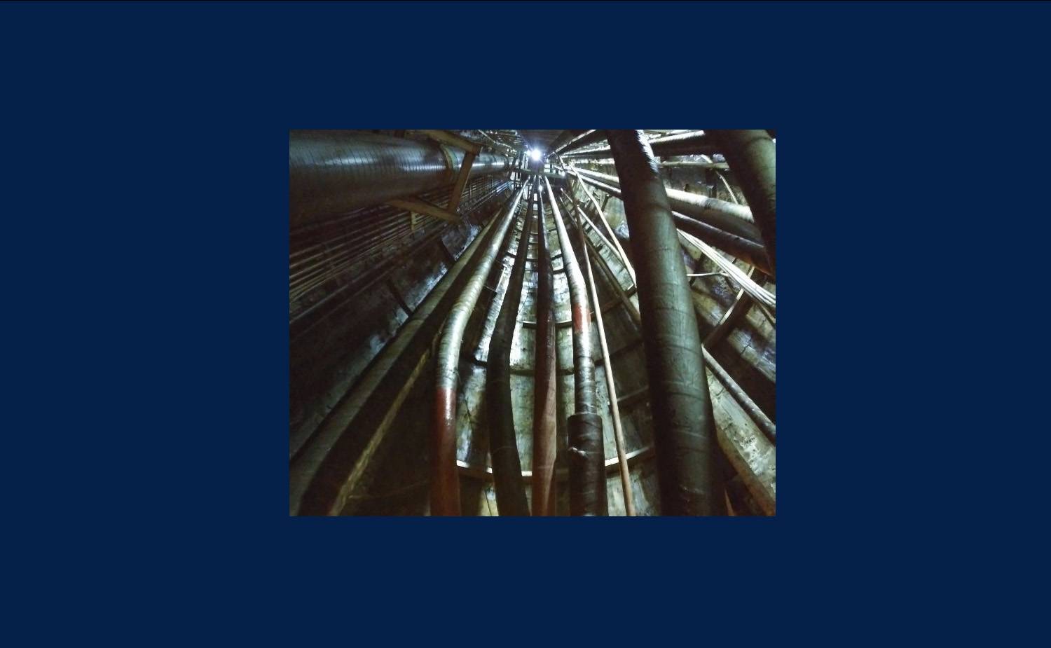 Tunnel with gray subway cables underneath the tracks