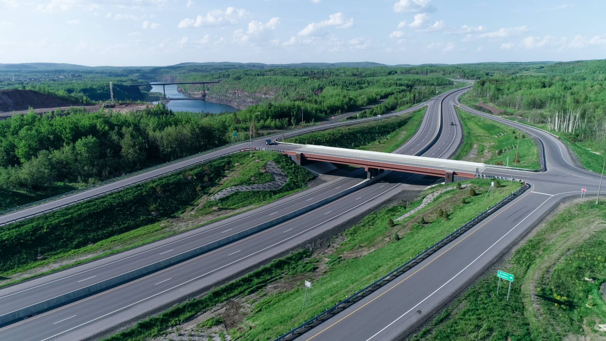 Landscape of roadway and bridges with a river and trees